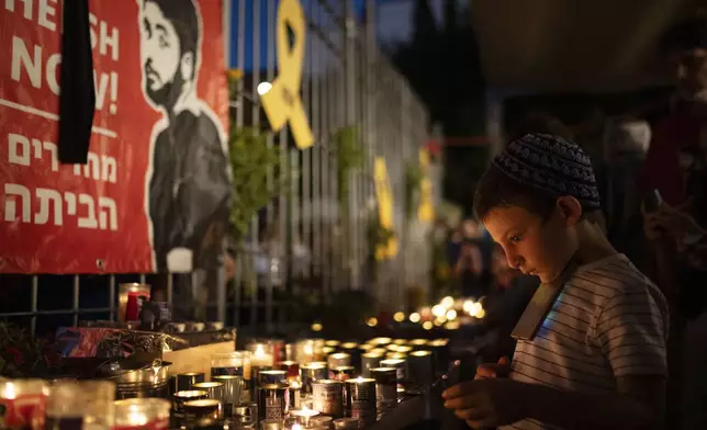 People light candles during a vigil in memory of slain hostage Hersh Goldberg-Polin in Jerusalem, Israel, Sunday, Sept. 1, 2024. (AP Photo/Leo Correa)