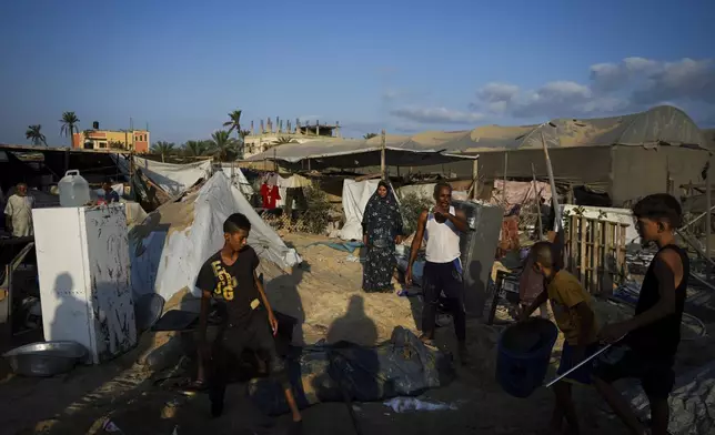 Palestinians look at the destruction after an Israeli airstrike on a crowded tent camp housing Palestinians displaced by the war in Muwasi, Gaza Strip, Tuesday, Sept. 10, 2024. An Israeli strike killed at least 40 people and wounded 60 others early Tuesday, Palestinian officials said. Israel said it targeted "significant" Hamas militants, allegations denied by the militant group. (AP Photo/Abdel Kareem Hana)