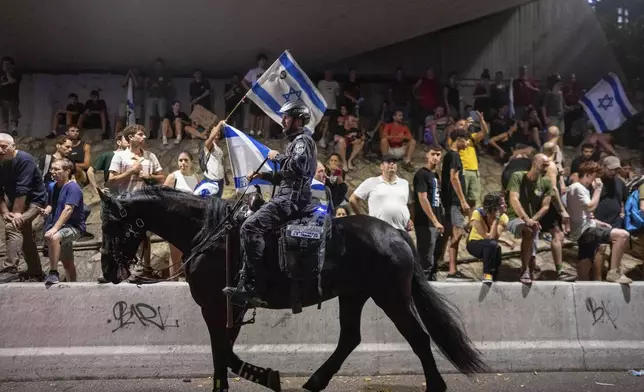 A police officer on a horse moves past a protest calling for a deal for the immediate release of hostages held in the Gaza Strip by Hamas, in Tel Aviv, Israel, Sunday, Sept. 1, 2024. (AP Photo/Ohad Zwigenberg)