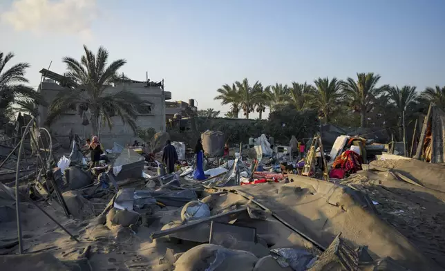 Palestinians look at the destruction after an Israeli airstrike on a crowded tent camp housing Palestinians displaced by the war in Muwasi, Gaza Strip, Tuesday, Sept. 10, 2024. An Israeli strike killed at least 40 people and wounded 60 others early Tuesday, Palestinian officials said. Israel said it targeted "significant" Hamas militants, allegations denied by the militant group. (AP Photo/Abdel Kareem Hana)