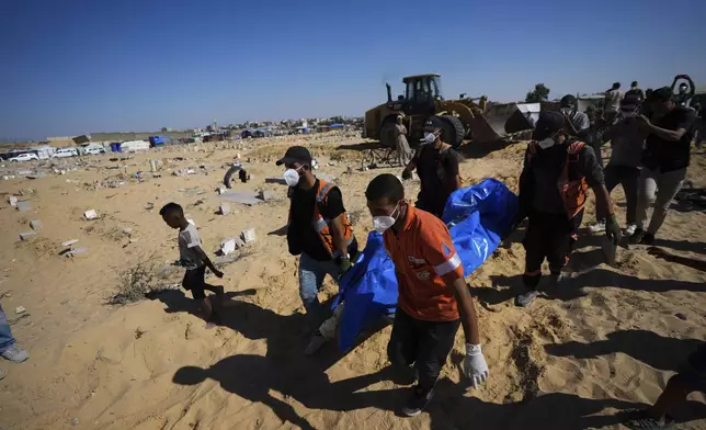 People bury the bodies of Palestinians taken by the Israeli military during operations in Gaza and returned this week, in Khan Younis, Gaza Strip, Thursday, Sept. 26, 2024. (AP Photo/Abdel Kareem Hana)