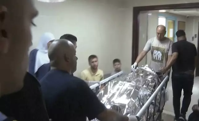 This image taken from an Associated Press video shows Aysenur Ezgi Eygi's body being transported through the Rafidia Surgical Hospital, where she was taken after she was fatally shot by Israeli soldiers, Sept. 6, 2024, in the West Bank city of Nablus. (AP Photo/Aref Tufaha)