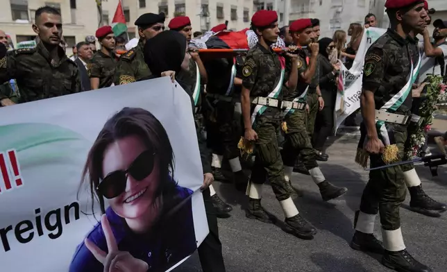 A Palestinian honor guard carries the body of Aysenur Ezgi Eygi, 26, who was fatally shot by Israeli soldiers while participating in an anti-settlement protest in the West Bank, during her funeral procession in the West Bank city of Nablus, Monday, Sept. 9, 2024. (AP Photo/Nasser Nasser)