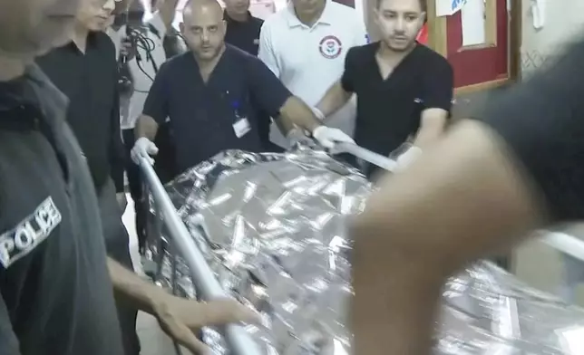 This image taken from an Associated Press video shows Aysenur Ezgi Eygi's body being transported through the Rafidia Surgical Hospital, where she was taken after she was fatally shot by Israeli soldiers, Sept. 6, 2024, in the West Bank city of Nablus. (AP Photo/Aref Tufaha)