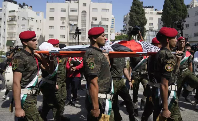 A Palestinian honor guard carries the body of Aysenur Ezgi Eygi, 26, who was fatally shot by Israeli soldiers while participating in an anti-settlement protest in the West Bank, during her funeral procession in the West Bank city of Nablus, Monday, Sept. 9, 2024. (AP Photo/Nasser Nasser)