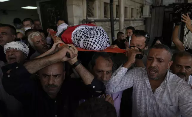 Mourners carry the body of Aysenur Ezgi Eygi, 26, who was fatally shot by Israeli soldiers while participating in an anti-settlement protest in the West Bank, during her funeral procession in the West Bank city of Nablus, Monday, Sept. 9, 2024. (AP Photo/Nasser Nasser)