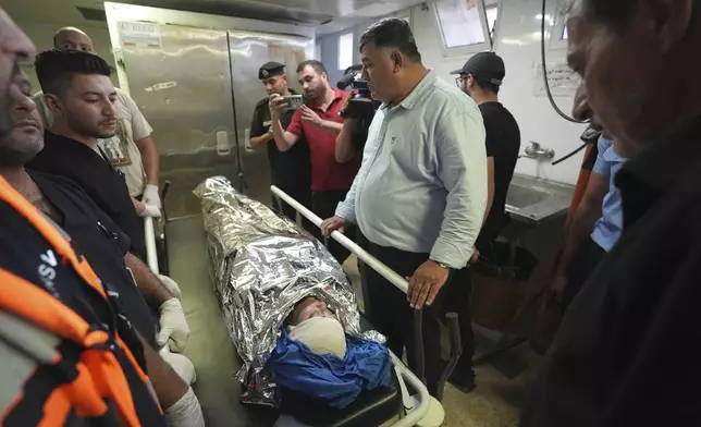 Palestinians gather around the body of Aysenur Ezgi Eygi, 26, who was fatally shot by Israeli soldiers while participating in an anti-settlement protest in the West Bank, at the morgue of the Rafedia hospital in the West Bank city of Nablus Friday, Sept. 6, 2024. (AP Photo)