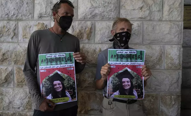 Two fellow activists of Aysenur Ezgi Eygi, 26, who was fatally shot by Israeli soldiers while participating in an anti-settlement protest in the West Bank, carry posters with her name and photo during Eygi's funeral procession in the West Bank city of Nablus, Monday, Sept. 9, 2024. (AP Photo/Nasser Nasser)