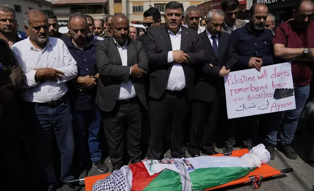 Mourners pray over the body of Aysenur Ezgi Eygi, 26, who was fatally shot by Israeli soldiers while participating in an anti-settlement protest in the West Bank, during her funeral procession in the West Bank city of Nablus, Monday, Sept. 9, 2024. (AP Photo/Nasser Nasser)