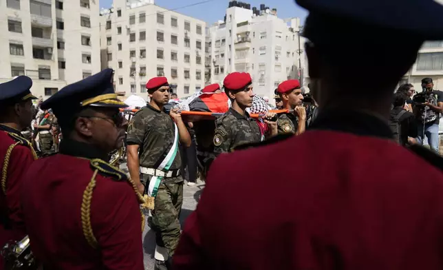 A Palestinian honor guard carries the body of Aysenur Ezgi Eygi, 26, who was fatally shot by Israeli soldiers while participating in an anti-settlement protest in the West Bank, during her funeral procession in the West Bank city of Nablus, Monday, Sept. 9, 2024. (AP Photo/Nasser Nasser)