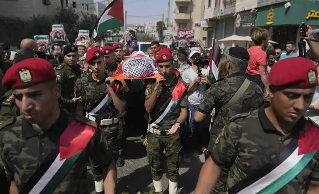 A Palestinian honor guard carries the body of Aysenur Ezgi Eygi, 26, who was fatally shot by Israeli soldiers while participating in an anti-settlement protest in the West Bank, during her funeral procession in the West Bank city of Nablus, Monday, Sept. 9, 2024. (AP Photo/Nasser Nasser)