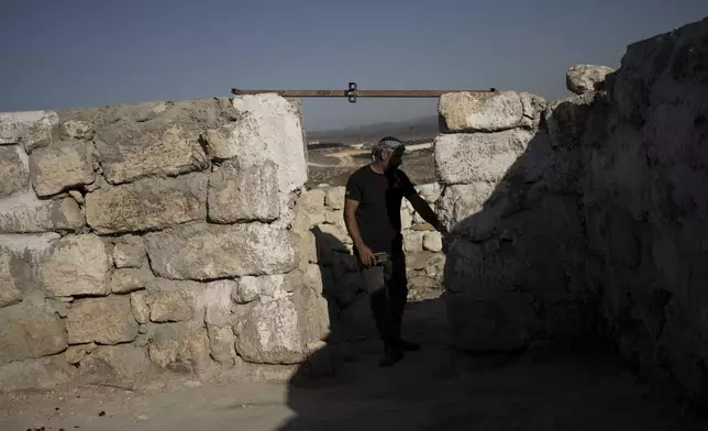 Hassan Battat stands in what remains of his home in the West Bank village of Khirbet Zanuta, Thursday, Aug. 29, 2024. Ten months after settlers threatened to kill them if they didn't leave their village, some Palestinian residents are finally home, under a rare court order. (AP Photo/Maya Alleruzzo)