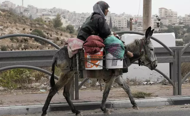 A Palestinian woman rides her donkey near the West Bank city of Bethlehem, Monday, Sept. 16, 2024. (AP Photo/Mahmoud Illean)