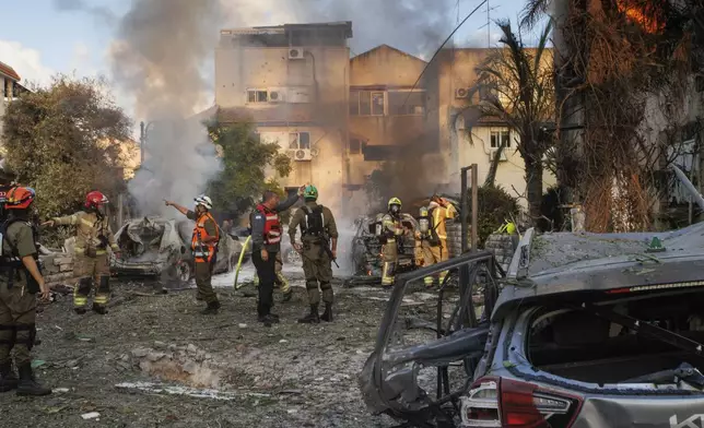 Israeli security forces work at the site hit by a rocket fired from Lebanon, in Kiryat Bialik, northern Israel, on Sunday, Sept. 22, 2024. (AP Photo/Gil Nechushtan)