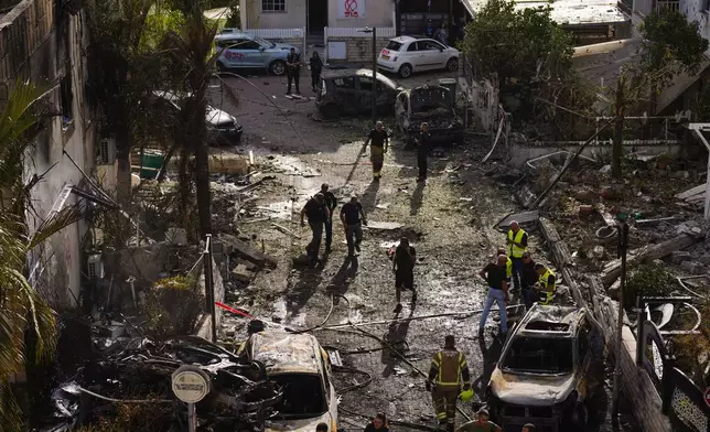 Israeli security forces examine the site hit by a rocket fired from Lebanon, in Kiryat Bialik, northern Israel, on Sunday, Sept. 22, 2024. (AP Photo//Ariel Schalit)