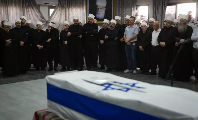 Mourners gather around the flag-draped casket of Israeli reservist Major Nael Fwarsy, one of two soldiers killed by a Lebanese drone attack on northern Israel, during his funeral in Maghar, Israel, Friday, Sept 20, 2024. (AP Photo/Ohad Zwigenberg)