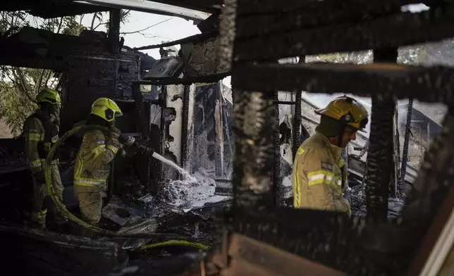 Israeli firefighters work at a house that was hit by a rocket fired from Lebanon, near the city of Safed, northern Israel, on Saturday, Sept. 21, 2024. (AP Photo//Leo Correa)