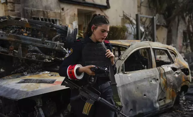 An Israeli police officer examines the site hit by a rocket fired from Lebanon, in Kiryat Bialik, northern Israel, on Sunday, Sept. 22, 2024. (AP Photo//Ariel Schalit)