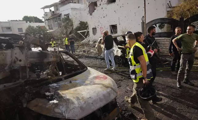 Israeli security forces examine the site hit by a rocket fired from Lebanon, in Kiryat Bialik, northern Israel, on Sunday, Sept. 22, 2024. (AP Photo//Ariel Schalit)