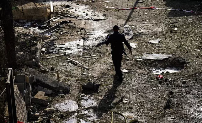 Israeli security forces examine the site hit by a rocket fired from Lebanon, in Kiryat Bialik, northern Israel, on Sunday, Sept. 22, 2024. (AP Photo//Ariel Schalit)