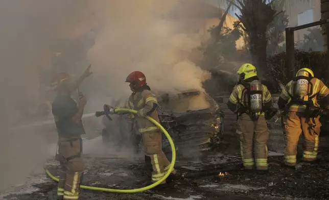 Israeli security and rescue forces work at the site hit by a rocket fired from Lebanon, in Kiryat Bialik, northern Israel, on Sunday, Sept. 22, 2024. (AP Photo/Gil Nechushtan)