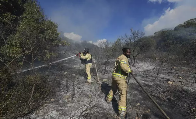 Israeli firefighters work to extinguish a fire after a rocket fired from Lebanon hit an open field in northern Israel, Wednesday, Sept. 18, 2024. (AP Photo/Baz Ratner)