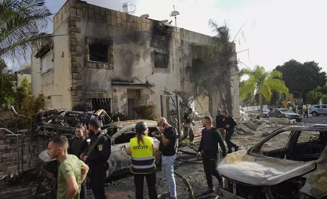 Israeli security forces examine the site hit by a rocket fired from Lebanon, in Kiryat Bialik, northern Israel, on Sunday, Sept. 22, 2024. (AP Photo//Ariel Schalit)