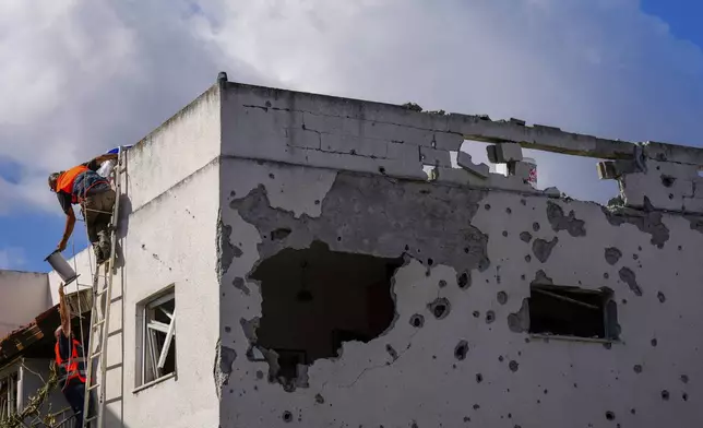 Israeli security forces work at a house hit by a rocket fired from Lebanon, in Kiryat Bialik, northern Israel, on Sunday, Sept. 22, 2024. (AP Photo//Ariel Schalit)