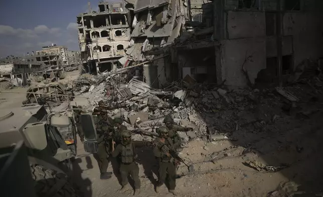 Israeli soldiers take up position next to buildings destroyed by the Israeli military in the Gaza Strip on Friday, Sept. 13, 2024. (AP Photo/Leo Correa)