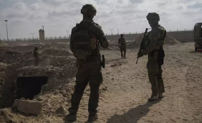 Israeli soldiers take up positions next to an entrance of a tunnel which the military says Hamas militants used in the southern Gaza Strip, about a 100 meters from the Philadelphi corridor along the border with Egypt, during a ground operation on Friday, Sept. 13, 2024. (AP Photo/Leo Correa)