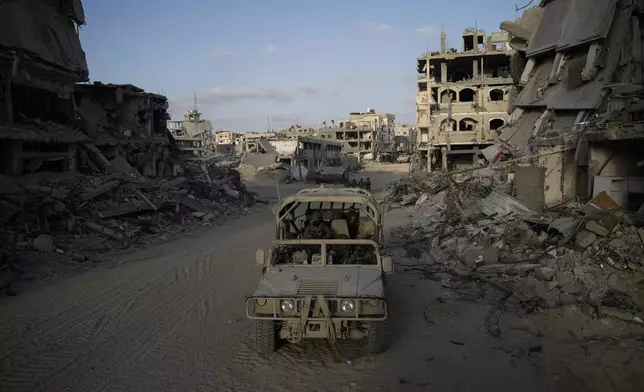 Israeli soldiers move next to destroyed buildings following Israeli strikes during a ground operation in the Gaza Strip on Friday, Sept. 13, 2024. (AP Photo/Leo Correa)