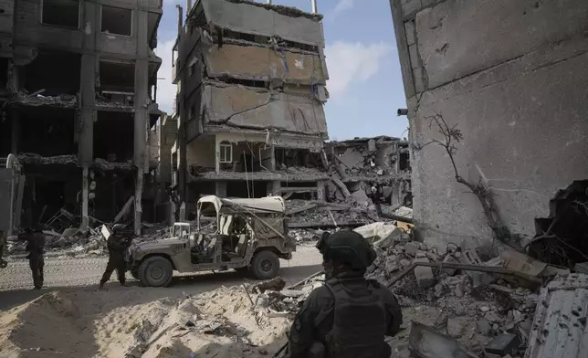 Israeli soldiers take up position next to buildings destroyed by the Israeli military in the Gaza Strip on Friday, Sept. 13, 2024. (AP Photo/Leo Correa)