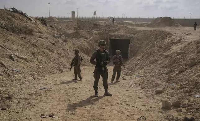 Israeli soldiers take up positions next to an entrance of a tunnel which the military says Hamas militants used in the southern Gaza Strip, about a 100 meters from the Philadelphi corridor along the border with Egypt, during a ground operation on Friday, Sept. 13, 2024. (AP Photo/Leo Correa)