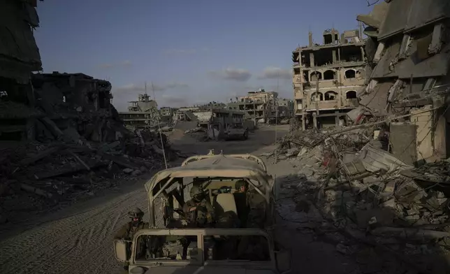 Israeli soldiers move next to buildings destroyed by the Israeli military in the Gaza Strip on Friday, Sept. 13, 2024. (AP Photo/Leo Correa)