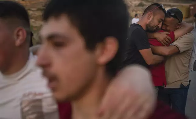 Family members embrace a man who was just released from prison near Ramallah, West Bank, Thursday, June 13, 2024. (AP Photo/Bram Janssen)