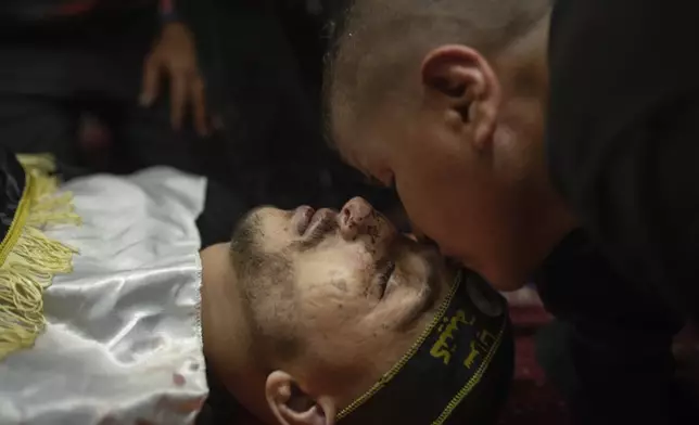 Murat, 12, kisses the body of his uncle, Odei, 22, at a mosque in Jenin, West Bank, Thursday, June 6, 2024. Odei was killed by Israeli forces during a raid inside the Jenin refugee camp. (AP Photo/Bram Janssen)