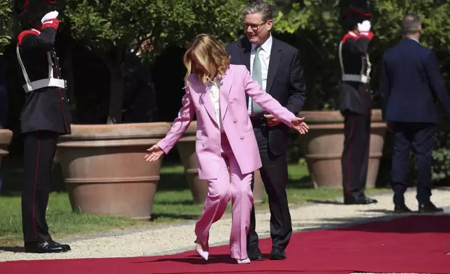 Italian Prime Minister Giorgia Meloni indicates to British Prime Minister Keir Starmer where to stand on the occasion of their meeting at Villa Doria Pamphilj in Rome, Monday, Sept. 16, 2024. (Phil Noble/Pool Photo via AP)