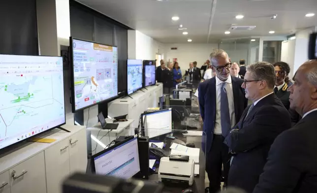 British Prime Minister Keir Starmer looks at screens showing the maritime traffic off the Italian coast during his visit to Italy’s national immigration crime coordination center, in Rome, Monday, Sept. 16, 2024. (Phil Noble/Pool Photo via AP)