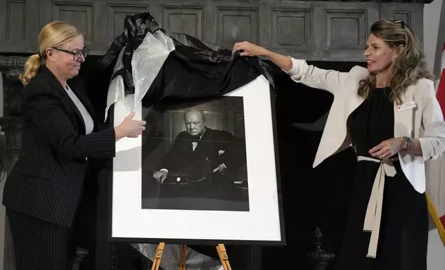 Canadian Cultural Heritage Deputy Minister, Isabelle Mondou, left, and Andrea Clark-Grignon, Head of Public Affairs, unveil a photographic portrait known as 'The Roaring Lion', taken by photographer Yousuf Karsh in 1941 of Britain's Prime Minister Winston Churchill, stolen in Canada in 2022, and returned during a ceremony at the Canada's embassy in Rome, Thursday, Sept. 19, 2024. (AP Photo/Alessandra Tarantino)