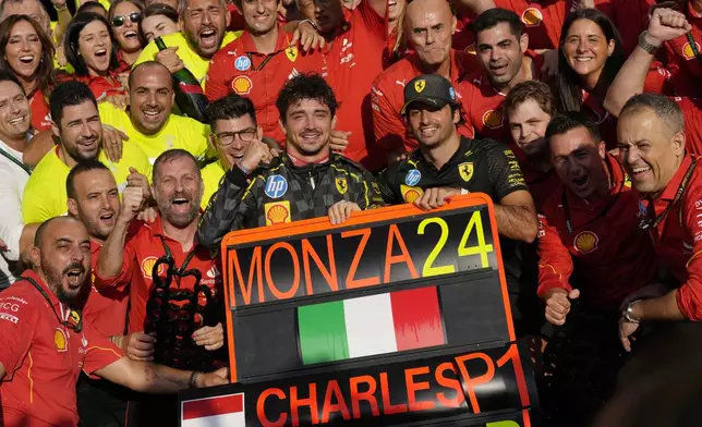 Ferrari driver Charles Leclerc of Monaco celebrates with his teammate Ferrari driver Carlos Sainz of Spain in the Ferrari garage after winning the Italy's Formula One Grand Prix at the Monza racetrack, in Monza, Italy, Sunday, Sep.1, 2024 (AP Photo/Luca Bruno)