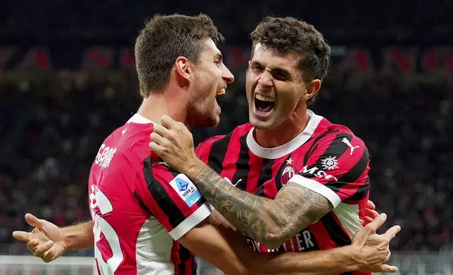 AC Milan's Matteo Gabbia, left, celebrates with teammate Christian Pulisic after scoring in a Serie A soccer match between AC Milan and Venezia at the San Siro Stadium in Milan, Italy, Saturday, Sept. 14, 2024. (Spada/LaPresse via AP)