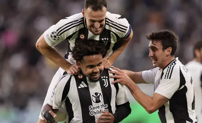 Juventus' Weston McKennie celebrates with teammates Federico Gatti, top, and Andrea Cambiaso, right, after scoring his side's second goal during the Champions League opening phase soccer match between Juventus and PSV Eindhoven at the Juventus stadium in Turin, Italy, Tuesday, Sept. 17, 2024. (Fabio Ferrari/LaPresse via AP)