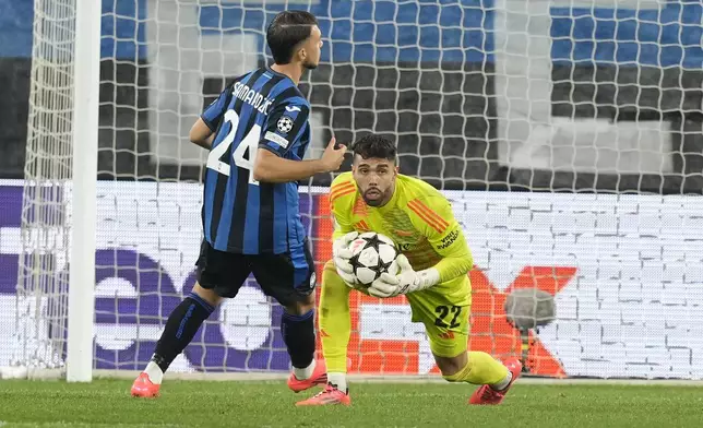 Arsenal's goalkeeper David Raya, centre, makes a save during the Champions League opening phase soccer match between Atalanta and Arsenal at the Bergamo's stadium in Bergamo, Italy, Thursday, Sept. 19, 2024. (AP Photo/Antonio Calanni)