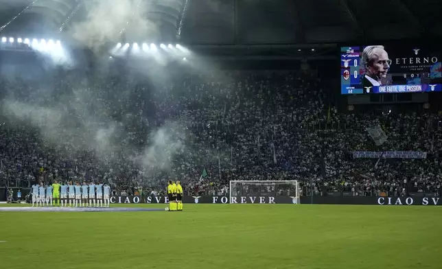 Lazio players stand together on the pitch and a picture of Swedish coach Sven-Goran Eriksson is displayed on the screen during a tribute to the former Lazio coach who passed away recently, before a Serie A soccer match between Lazio and AC Milan, at Rome's Stadio Olimpico, Saturday, Aug. 31, 2024. (AP Photo/Andrew Medichini)