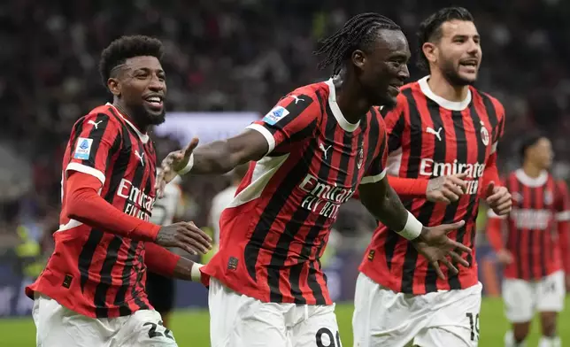 AC Milan's Tammy Abraham, center, celebrates after he scored during the Serie A soccer match between AC Milan and Venezia at the San Siro stadium in Milan, Italy, Saturday, Sept. 14, 2024. (AP Photo/Antonio Calanni)