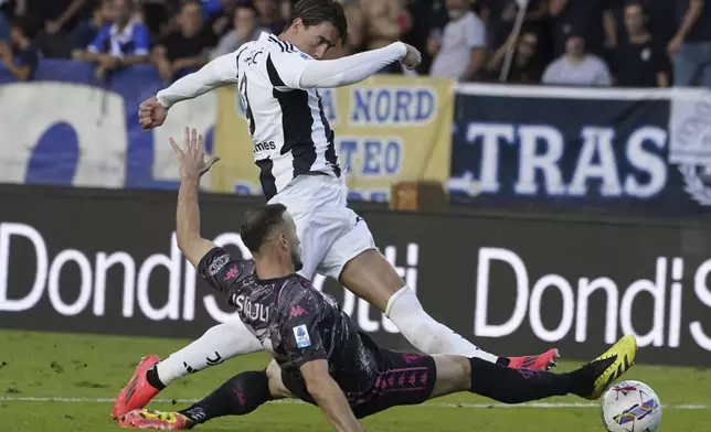 Juventus Dusan Vlahovic, top, is tackled by Empoli's Ardian Ismajli during the Italian Serie A soccer match between Empoli and Juventus at the Carlo Castellani Stadium in Empoli, Italy, Saturday, Sept. 14, 2024. (Marco Bucco/LaPresse via AP)
