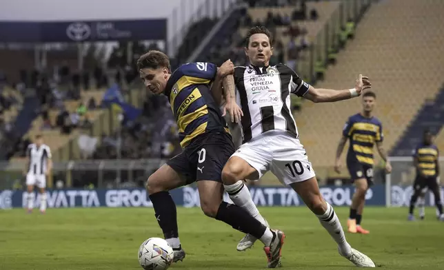 Udinese's Florian Thauvin, right, fights for the ball with Parma's Adrian Bernabe, left, during the Serie A soccer match between Parma and Udinese in Parma, Italy, Monday Sept. 16, 2024. (Massimo Paolone/LaPresse via AP)