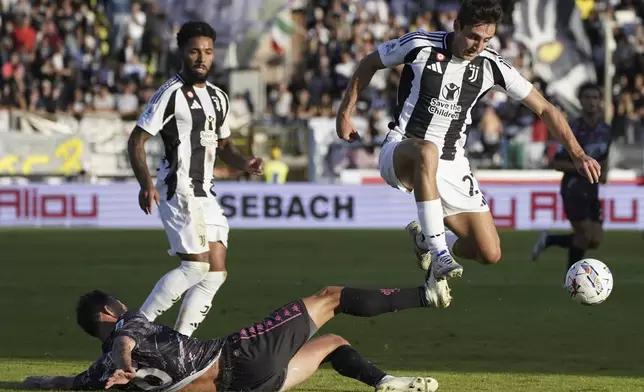 Juventus' Andrea Cambiaso, right, jumps past Empoli's Liam Henderson during the Italian Serie A soccer match between Empoli and Juventus at the Carlo Castellani Stadium in Empoli, Italy, Saturday, Sept. 14, 2024. (Marco Bucco/LaPresse via AP)