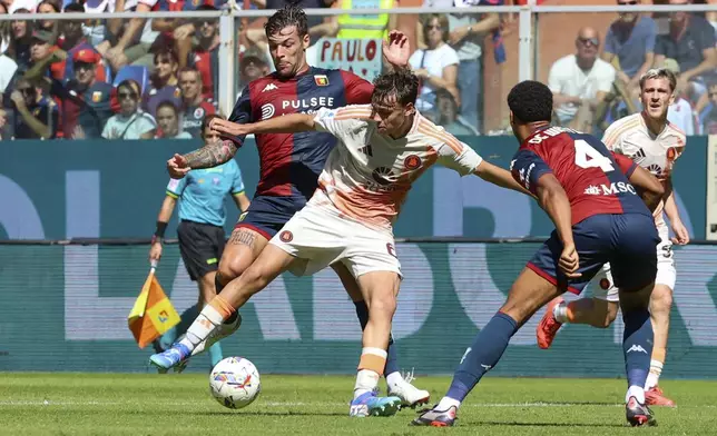 Genoa's Alessandro Vogliacco fights for the ball with Roma's Niccolo Pisilli, left, during the Serie A soccer match between Genoa and Roma at the Luigi Ferraris Stadium in Genoa, Italy, Sunday, Sept. 15, 2024. (Tano Pecoraro/LaPresse via AP)