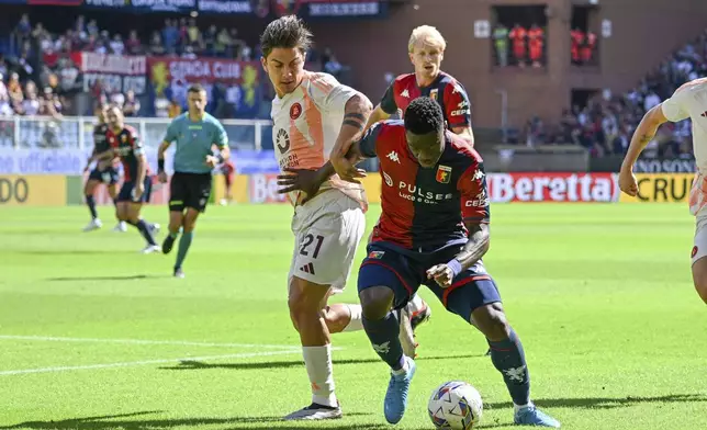 Genoa's Caleb Ekuban, left, and Roma's Paulo Dybala battle for the ball during the Serie A soccer match between Genoa and Roma at the Luigi Ferraris Stadium in Genoa, Italy, Sunday, Sept. 15, 2024. (Tano Pecoraro/LaPresse via AP)